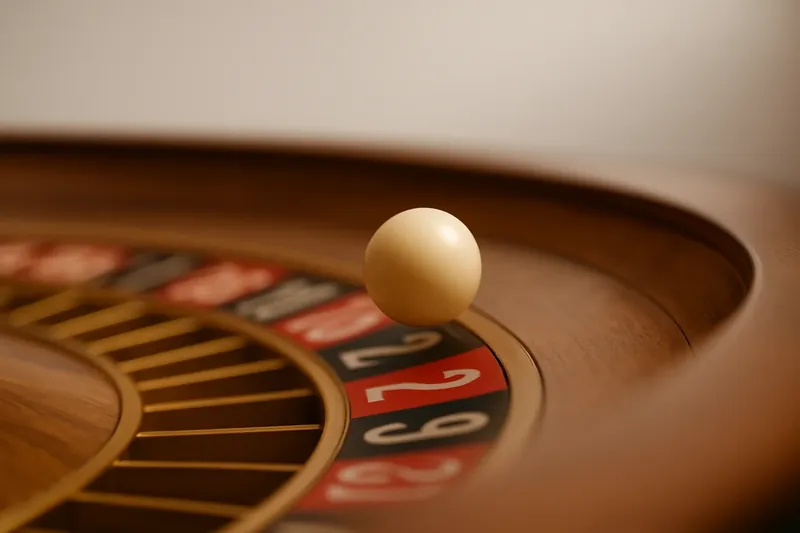 Roulette ball frozen mid-roll on wheel rim with blurred numbers